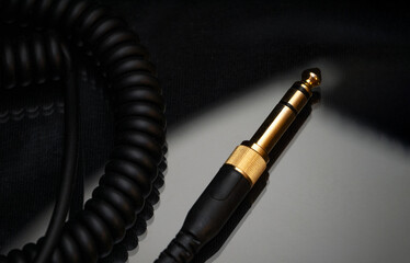 Gold-plated TRS connector for the analog audio signal are placed against a black background....