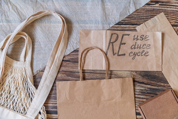 Reduce, reuse, recycle, refill. Eco friendly shopping bags on wooden background. Zero waste sustainable lifestyle. Plastic free concept.