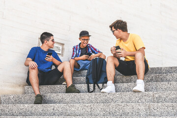 Teenagers friends using smartphone together. Smiling teens browsing social media online. Boys...