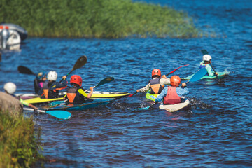 Kids learn kayaking, canoeing whitewater training in the lake river, children practicing paddling, yound kayakers in summer camp