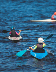 Kids learn kayaking, canoeing whitewater training in the lake river, children practicing paddling,...