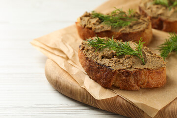 Fototapeta na wymiar Slices of bread with delicious pate and dill on white wooden table, closeup. Space for text