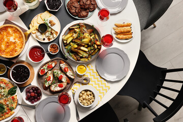 Brunch table setting with different delicious food and chairs indoors, top view
