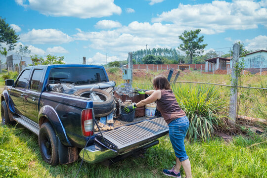 A woman loads garbage onto a pickup truck in Paraguay.