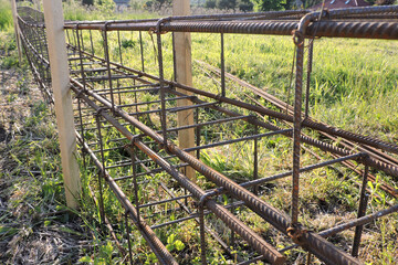 The close-up of the steel rebar made of reinforcing bars and steel wires, green grass