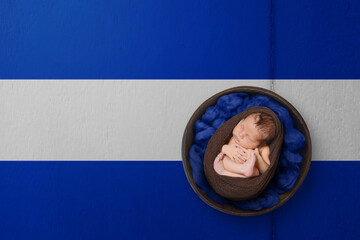 Newborn portrait on background in color of national flag. Patriotic photography concept. Honduras