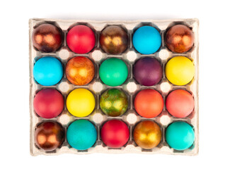 Top view of Easter colored eggs in a cardboard box on a white background.