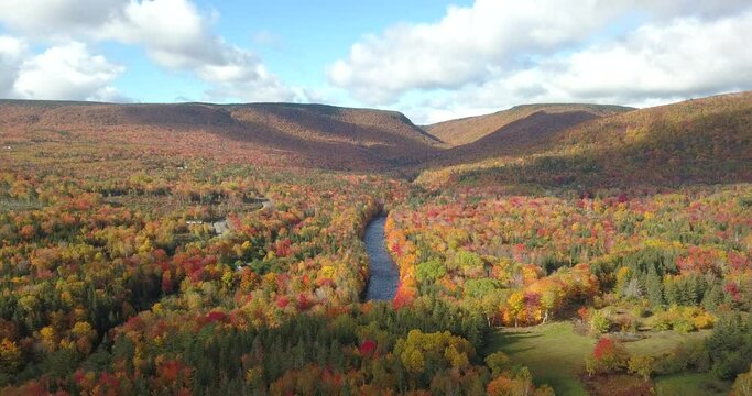 Aerial views of the famous Cabot Trail along the North River, Oregon, Cape Breton, Nova Scotia in Autumn. Fall foliage of the mountains with multi-colored deciduous trees. 
