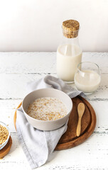 Healthy milky porridge from whole hulled grain oats in bowl with oat milk