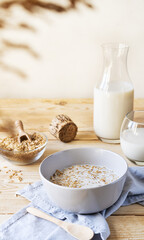 Healthy milky porridge from whole hulled grain oats in bowl with oat milk