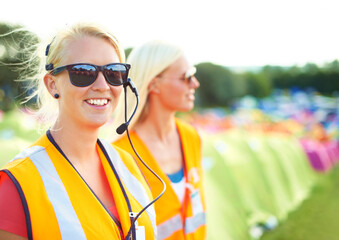 Making sure everything goes smoothly. Two young female security assistants standing on a campsite...