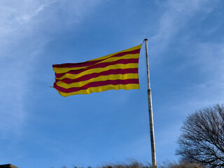 Catalan Flag fluttering with a blue sky in the background