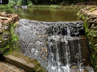 Cascata de pedras artificial, logo após pequeno lago de nascente com águas cristalinas, localizada no parque das Mangabeiras, Belo Horizonte, Minas Gerias.