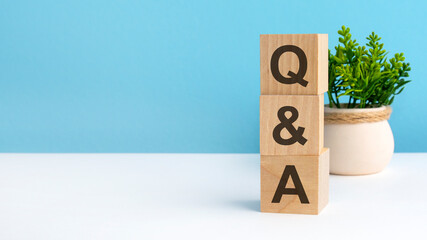 Q AND A - acronym from wooden blocks with letters, questions and answers. concept on grey...
