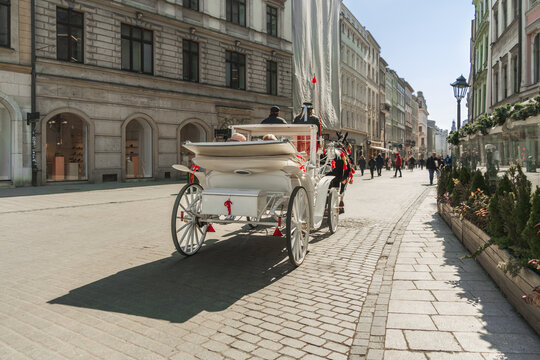 Krakow horse-drawn carriage on a stone-paved street on a sunny day