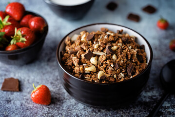 Chocolate nuts oatmeal granola with chocolate slices in a bowl