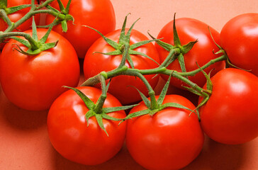 Bunch of fresh tomatoes on red background.