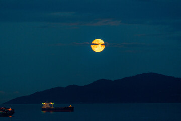 the orange full moon set in the earlier morning