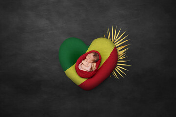 Newborn portrait on heart in color of national flag. Photography peace concept. Congo