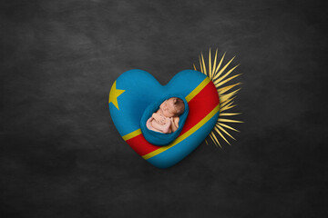 Newborn portrait on heart in color of national flag. Photography peace concept. Democratic Republic of the Congo