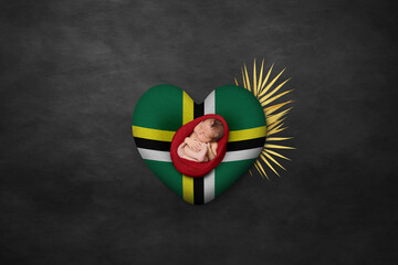 Newborn portrait on heart in color of national flag. Photography peace concept. Dominica