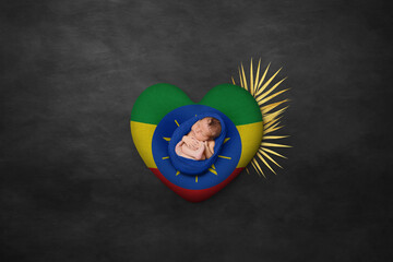 Newborn portrait on heart in color of national flag. Photography peace concept. Ethiopia