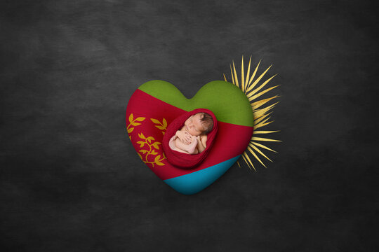 Newborn portrait on heart in color of national flag. Photography peace concept. Eritrea