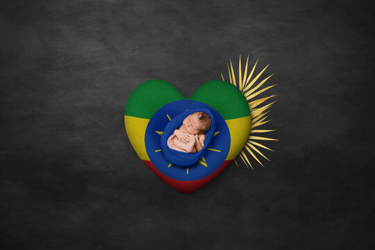 Newborn portrait on heart in color of national flag. Photography peace concept. Ethiopia