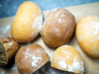 Bakery products.  Buns on a cutting board. Rye and wheat buns. Products from premium wheat flour and rye flour.