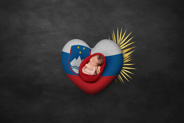 Newborn portrait on heart in color of national flag. Photography peace concept. Slovenia
