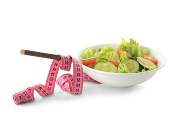 Bowl of fresh salad and measuring tape on white background