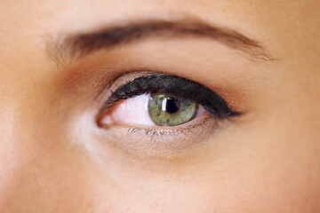 Beautifully made-up eye. Closeup of a vivid green eye with thick mascara-coated lashes.