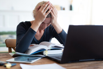 Tired student having a lot to read at home.