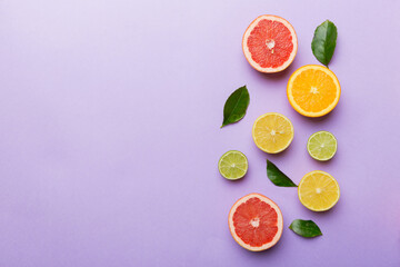 Fruit background. Colorful fresh fruits on colored table. Orange, lemon, grapefruit Space for text healthy concept. Flat lay, top view, copy space