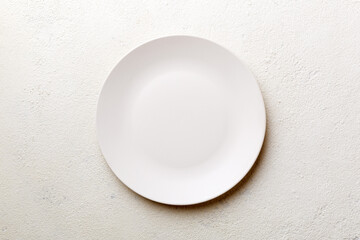 Top view of empty light plate on cement background. Empty space for your design