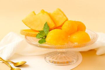 Fototapeta na wymiar Dessert stand with tasty sorbet and melon pieces on beige background