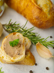 Close-up. Canape with foie gras, garlic and rosemary sprigs. in the background is a baguette. Isolated on white background. Restaurant, hotel, banquet, buffet, cookbook. Food background.