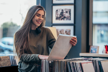 Woman choosing vinyl record in music record shop