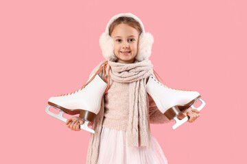 Cute little girl in winter clothes and with ice skates on color background