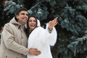 Loving couple in park on snowy winter day