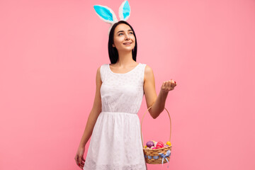 beautiful woman in rabbit ears with a basket of Easter eggs, on the Easter holiday