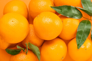 Many ripe oranges and leaves as background, closeup