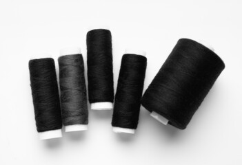 Black thread spools on white background