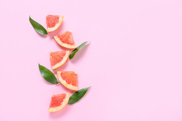 Fresh grapefruit slices on pink background