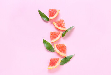 Fresh grapefruit slices on pink background
