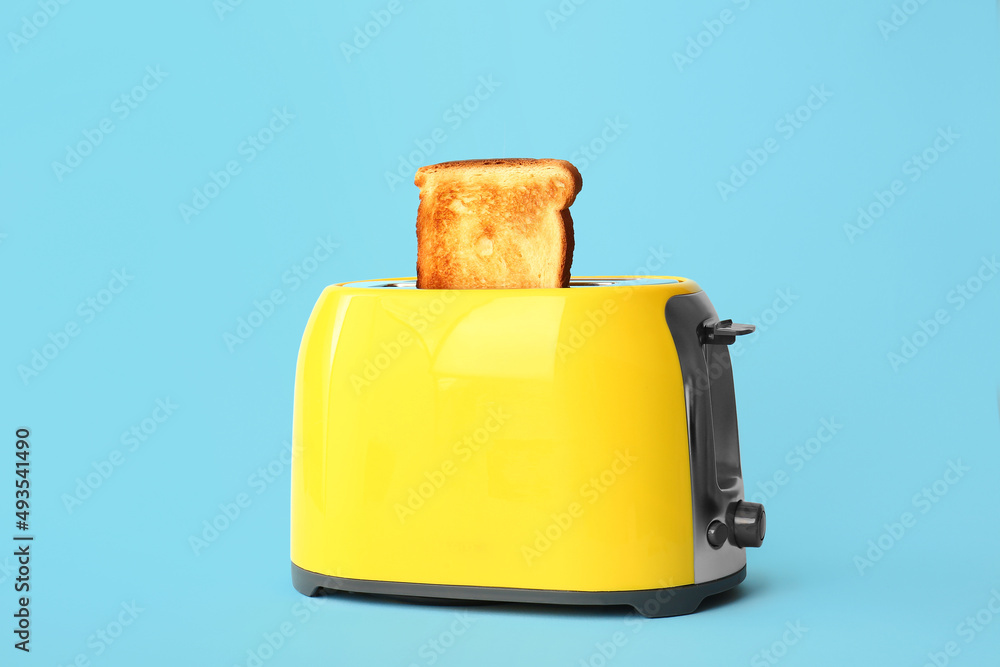 Canvas Prints Modern toaster with bread slice on blue background