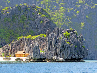 Traditional Filipino House with limestone rock background of an island in Coron, Palawan, Philippines