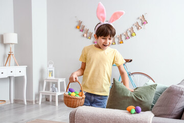 Cute little boy looking for hidden Easter eggs at home