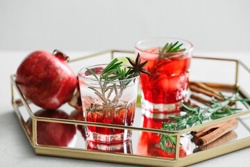 Glasses of tasty pomegranate cocktail on white background