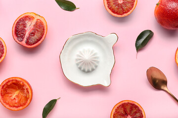 Ceramic juicer and grapefruits on pink background